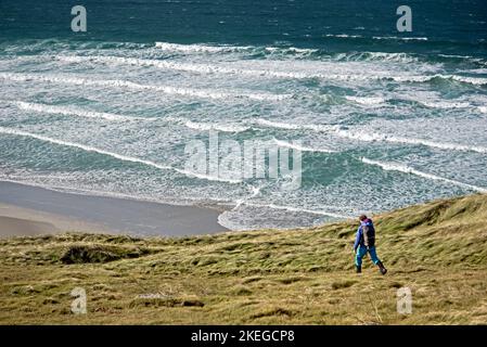 Die Wandererin macht sich auf den Weg nach Traigh Eais, dem „Strand des Wasserfalls“ in Scots Gaellic, bei Eoligarry, auf der Insel Barra in den Äußeren Hebriden. Stockfoto