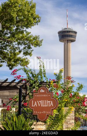 Das Einkaufsviertel La Villita mit dem Tower of the Americas an einem sonnigen Sommertag. Stadt symbolisch und Attraktion Turm. Stockfoto