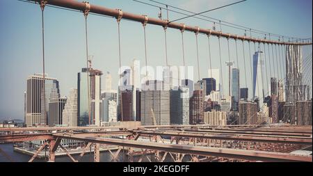 Retro-getöntes Bild der New Yorker Stadtlandschaft, gesehen durch die Kabel der Brooklyn Bridge, USA. Stockfoto