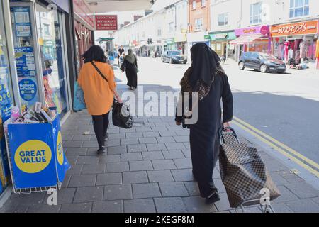 Muslimische Frauen kaufen an einem sonnigen Tag in der britischen Stadt ein. Stockfoto