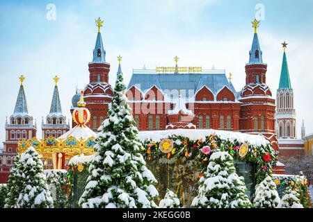 Manezhnaya-Platz im Winter, Moskau, Russland. Landschaft mit Weihnachtsbäumen und Dekorationen unter Schnee, Stadtzentrum bei Schneefall. Stockfoto