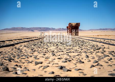 Eine verlassene Eisenbahn inmitten einer Wüste in Garub Namibia mit Bergen im Hintergrund Stockfoto