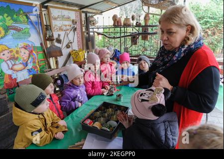 Lviv, Ukraine 12. November 2022. Die Ukrainer lehren Kinder, wie man im Zusammenhang mit dem kommenden Winter Grabenkerzen für die Streitkräfte der Ukraine herstellt. Grabenkerzen werden aus leeren Dosen hergestellt, die in Wellpappe verpackt und mit Paraffin oder Wachs gefüllt sind. Grabenkerzen sorgen für Licht und Wärme. Russland marschierte am 24. Februar 2022 in die Ukraine ein und löste damit den größten militärischen Angriff in Europa seit dem Zweiten Weltkrieg aus Stockfoto