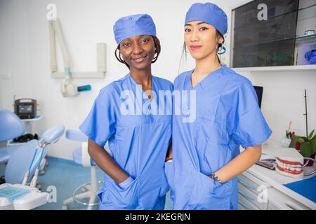 Zwei Ärztinnen in der Zahnarztpraxis, Kollegen verschiedener Ethnien. Stockfoto