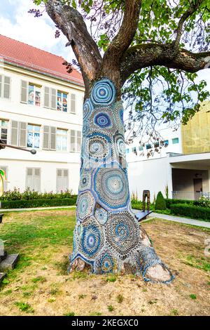 Mit Häkeln bedeckter Baumstamm außerhalb des Musée des Beaux-Arts, Mulhouse, Frankreich Stockfoto