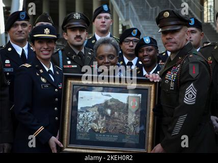 Chicago, Vereinigte Staaten Von Amerika. 11.. November 2022. Chicago, Vereinigte Staaten von Amerika. 11. November 2022. Chicago Mayor Lori E. Lightfoot, Mitte, posiert mit Soldaten der 1. Infanterie-Division, nachdem sie ihr ein Erinnerungsgeschenk während der City of Chicago Veterans Day Gedenkfeier auf Soldier Field am 11. November 2022 in Chicago, Illinois, überreicht hatten. Kredit: Pfc. Joshua Holliday/DOD Foto/Alamy Live News Stockfoto