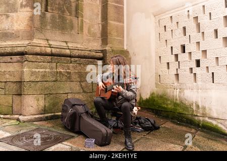 Santiago de Compostela, A coruna, Galicien, Spanien. 9. November 2022: Frau spielt Gitarre in Santiago auf der Straße Stockfoto