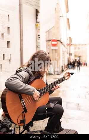 Santiago de Compostela, A coruna, Galicien, Spanien. 9. November 2022: Frau spielt Gitarre in Santiago auf der Straße Stockfoto