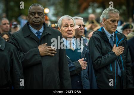 Washington, Vereinigte Staaten Von Amerika. 11.. November 2022. Washington, Vereinigte Staaten von Amerika. 11. November 2022. US-Verteidigungsminister Lloyd J. Austin III, links, steht neben dem ehemaligen Verteidigungsminister Chuck Hagel, Mitte, für die Nationalhymne. Und Sekretär der Veterans Administration, Denis McDonough während der Veterans Day Observanz am Vietnam Veterans Memorial, 11. November 2022 in Washington, DC der Tag markierte den 40.. Jahrestag der Gedenkfeier. Kredit: Chad J. McNeeley/DOD Foto/Alamy Live Nachrichten Stockfoto