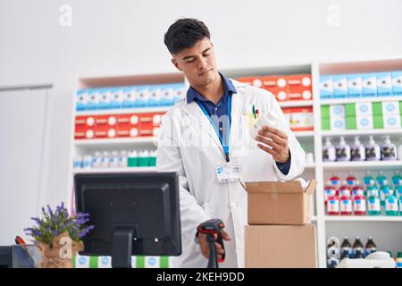 Junger hispanischer Apotheker, der Pillen in der Apotheke scannt Stockfoto