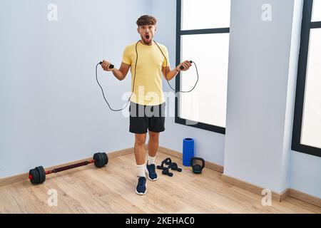 Arabischer Mann mit Barttraining mit Springseil im Schockgesicht, skeptisch und sarkastisch aussehend, überrascht mit offenem Mund Stockfoto
