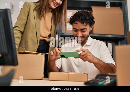 Mann und Frau Geschäftsleute machen Fotos, um im Büro zu verpacken Stockfoto