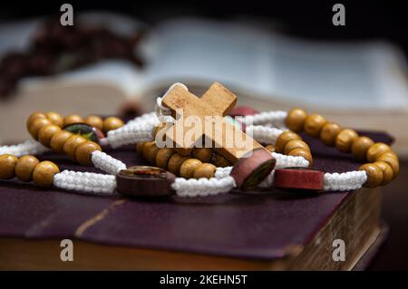 Heiliger Rosenkranz auf der Bibel mit anpassbarem Raum für religiöse Texte oder Ideen. Speicherplatz kopieren. Stockfoto