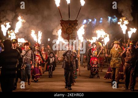 East Hoathly, Großbritannien. 12.. November 2022. Lagerfeuer der Erinnerung: Jährliche Karnevalsfeiern von East Hoathly an diesem Wochenende zum Gedenken an den Waffenstillstand- und Erinnerungssonntag. Die Sussex-Dorfbewohner tragen in einer Reihe von Prozessionen zur Lagerfeuerskulptur, die in diesem Jahr einen Löwen mit seiner Pfote auf einer Krone zeigt, um der Königin zu gedenken, flammende Feuerbanner und Fackeln. Kredit: Jim Holden/Alamy Live Nachrichten Stockfoto