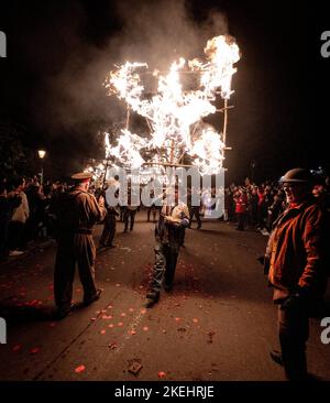 East Hoathly, Großbritannien. 12.. November 2022. Lagerfeuer der Erinnerung: Jährliche Karnevalsfeiern von East Hoathly an diesem Wochenende zum Gedenken an den Waffenstillstand- und Erinnerungssonntag. Die Sussex-Dorfbewohner tragen in einer Reihe von Prozessionen zur Lagerfeuerskulptur, die in diesem Jahr einen Löwen mit seiner Pfote auf einer Krone zeigt, um der Königin zu gedenken, flammende Feuerbanner und Fackeln. Kredit: Jim Holden/Alamy Live Nachrichten Stockfoto