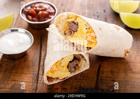 Frühstück Burrito mit Wurst, Eiern, Hashbraun und Käse Stockfoto