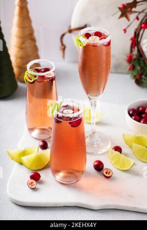 Weihnachtliche Mimosa mit Cranberry-Saft und Limette Stockfoto