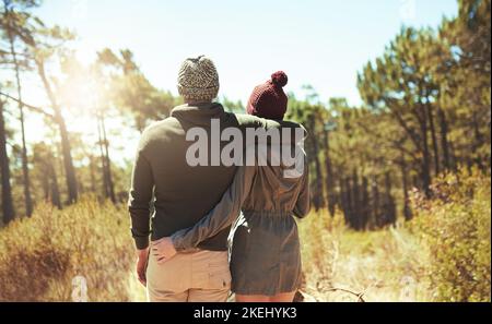 Erkunden Sie die Schönheit der Natur. Rückansicht eines liebevollen jungen Paares beim Wandern. Stockfoto