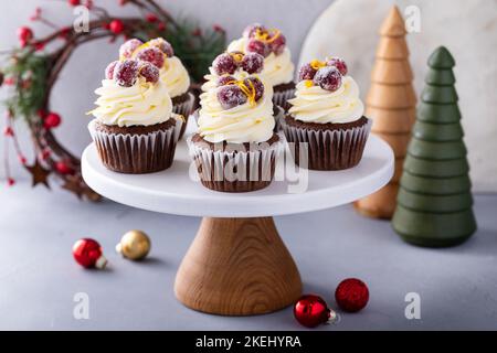 Gezuckerte Cranberry- und Orangenschokolade-Cupcakes mit Frischkäse-Zuckerguss Stockfoto