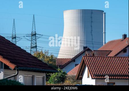 Niederaichbach, Deutschland. 27. Oktober 2022. Der Kühlturm des Kernkraftwerks Isar 2. Ist hinter Häusern in Niederaichbach zu sehen. Der Bundestag hat der vorübergehenden Fortsetzung des Betriebs der letzten drei deutschen Kernkraftwerke zur Sicherung der Stromversorgung zugestimmt, darunter das Kraftwerk Isar 2 in Essenbach im Landkreis Landshut. (To dpa-Korr ''The Lesser Evil' - Keine Aufregung am Standort von AKW Isar 2') Quelle: Armin Weigel/dpa/Alamy Live News Stockfoto