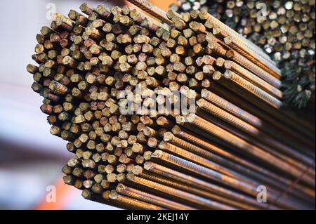 Dünne Metallstäbe stapeln sich auf einem großen Regal im Kühllager Stockfoto