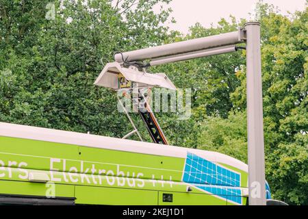 26. Juli 2022, Münster, Deutschland: Der Elektrobus wird nach der fertiggestellten Stadtstrecke aufgeladen. Das Problem der Ökologie und der grünen Energie im öffentlichen Transpor Stockfoto