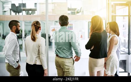 Mit einem Brainstorming ihr Geschäftspotenzial ausdehnen. Rückansicht eines Teams von Kollegen, das eine Brainstorming-Sitzung in einem Büro hat. Stockfoto