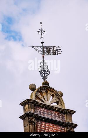 Windfahne auf dem Dach eines mittelalterlichen Gebäudes Stockfoto