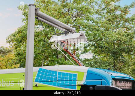 26. Juli 2022, Münster, Deutschland: Der Elektrobus wird nach der fertiggestellten Stadtstrecke aufgeladen. Das Problem der Ökologie und der grünen Energie im öffentlichen Transpor Stockfoto