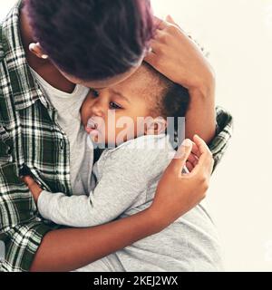 Ich halte meine ganze Welt in meinen Armen. Eine junge Mutter, die ihren kleinen Jungen schrackt. Stockfoto