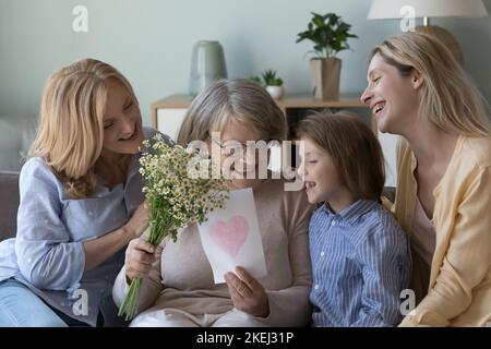 Liebevolle Frauen mit mehreren Generationen gratulieren älteren Oma zum Geburtstag Stockfoto