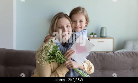 Porträt von lächelnder Mutter und kleiner Tochter, die Geburtstag feiern Stockfoto