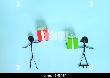 Weihnachtszeit oder Jubiläum Geschenk geben und teilen Konzept. Mann und Frau Paar Stockfigur Austausch von Geschenken. Stockfoto