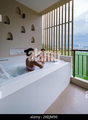 Ein Paar trinkt Champagner in einem Whirlpool während der Flitterwochen Stockfoto