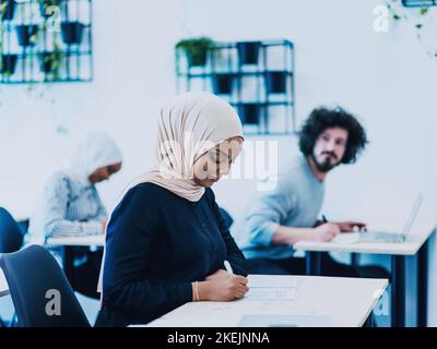 Foto einer afroamerikanischen muslimischen Frau, die in einem modernen Klassenzimmer über die Geschäftsentwicklung unterrichtet wird Stockfoto