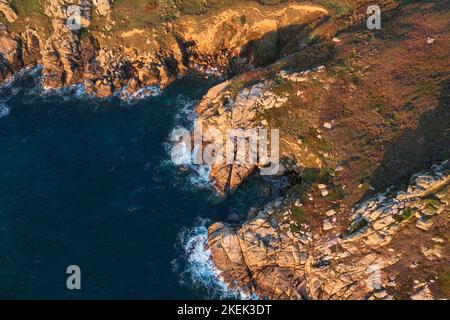 Luftdrohnen-Landschaftsbild des Minnack Theatre Vorgewende um den Porthcurno-Strand in Cornwall England bei Sonnenaufgang Stockfoto