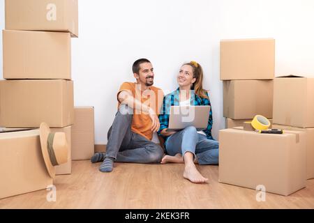 Attraktives junges Paar mit Umzugskartons, die unabhängig werden und einen neuen Haushaushaltsumzug eröffnen Stockfoto