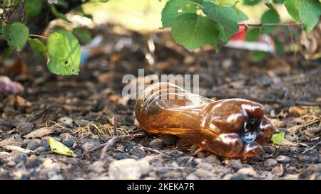 Nahaufnahme, auf dem Boden liegend alte gebrauchte Plastikflasche. Müll, Müll, Müll auf der Straße, im Freien. Ökologie, Umweltverschmutzung. Hochwertige Fotos Stockfoto