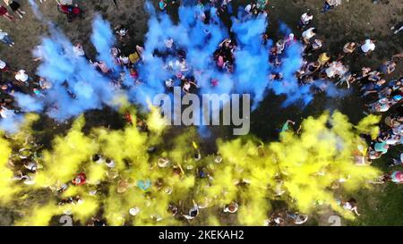 TSCHERKASY, UKRAINE - 24. AUGUST 2018 : Luftvideo mit Drohne, Feier des Unabhängigkeitstages, Fest der Farben, Menschen werfen gelbe und blaue Farben in den Himmel, Nationalflagge. Hochwertige Fotos Stockfoto