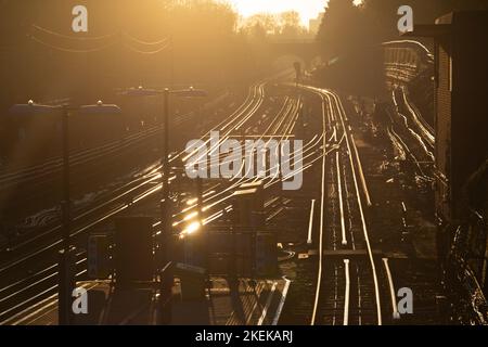 Ein dramatischer Blick auf die londoner U-Bahn goldenen Schienen am frühen Morgen.Blick in die Sonne keine Züge auf den Linien.könnte ein Streiktag sein Stockfoto