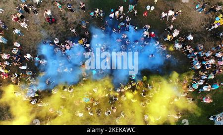 TSCHERKASY, UKRAINE - 24. AUGUST 2018 : Luftvideo mit Drohne, Feier des Unabhängigkeitstages, Fest der Farben, Menschen werfen gelbe und blaue Farben in den Himmel, Nationalflagge. Hochwertige Fotos Stockfoto