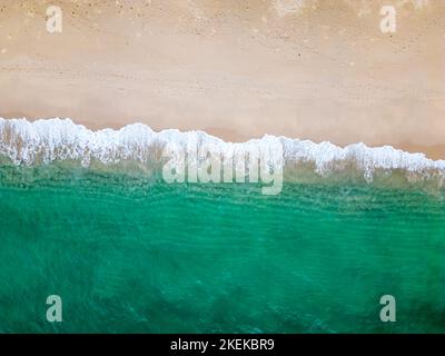 Luftdrohnen-Ansicht (von oben nach unten) zu Meereswellen und weißem Sand. Türkisblaues Wasser, tropisches Thema. Konzept der Entspannung in der Natur pur. Stockfoto