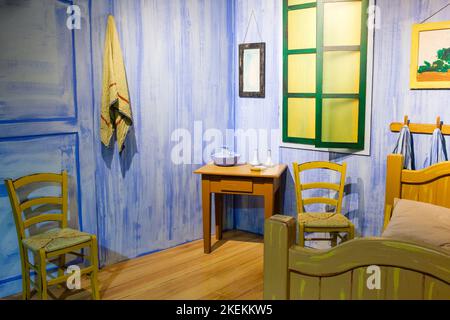 New Orleans, LA, USA - 15. Mai 2022: Szene mit Möbeln und gemaltem Hintergrund, um ein Van Gogh-Gemälde zu replizieren, La Chambre de Van Gogh a Arles Stockfoto