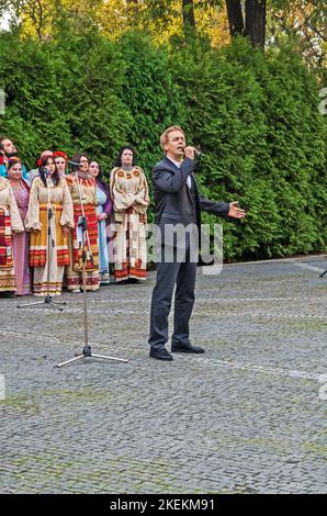 Dnipro, Ukraine - 14. Oktober 2022: Männlicher Sänger und Chor in nationalen ukrainischen Kostümen tritt auf dem Stadtplatz auf Stockfoto