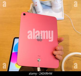 Paris, Frankreich - 28. Okt 2022: Nahaufnahme des neuen Apple Computers iPad 10. in rosa Farbe mit männlicher Hand im Geschäft - Blick auf die Heckkamera mit großen Logotypenabzeichen auf der Rückseite Stockfoto