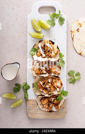 Würzige Blumenkohl-Tacos mit Koriander und mexikanischer Crema Stockfoto