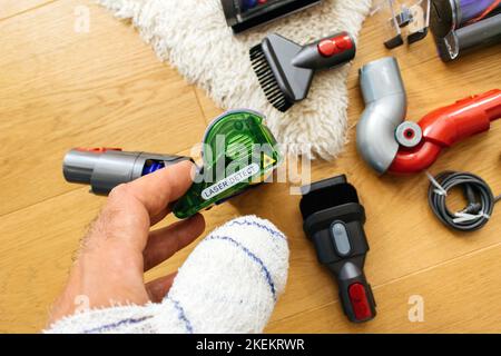 Paris, Frankreich - Jul 4, 2022: POV männliche Hand mit bandageten Finger beim Auspacken neuen Dyson Laser Slim flauschiger Reinigungskopf mit Aufkleber Laser Detect Stockfoto