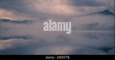 Am frühen Morgen hängt Nebel und niedrige Wolken über Derwentwater, English Lake District. Stockfoto