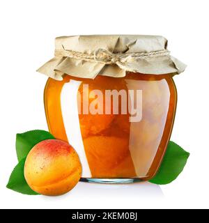 Aprikosenmarmelade im Glasgefäß, bedeckt mit auf Weiß isoliertem Geschenkpapier Stockfoto
