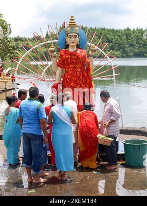 GRAND BASSIN, MAURITIUS - 24. FEBRUAR 2011: Familie betet vor der Statue der Hindu-Göttin Laksmi während des Hindu-Festivals von Maha Shivaratri in Stockfoto